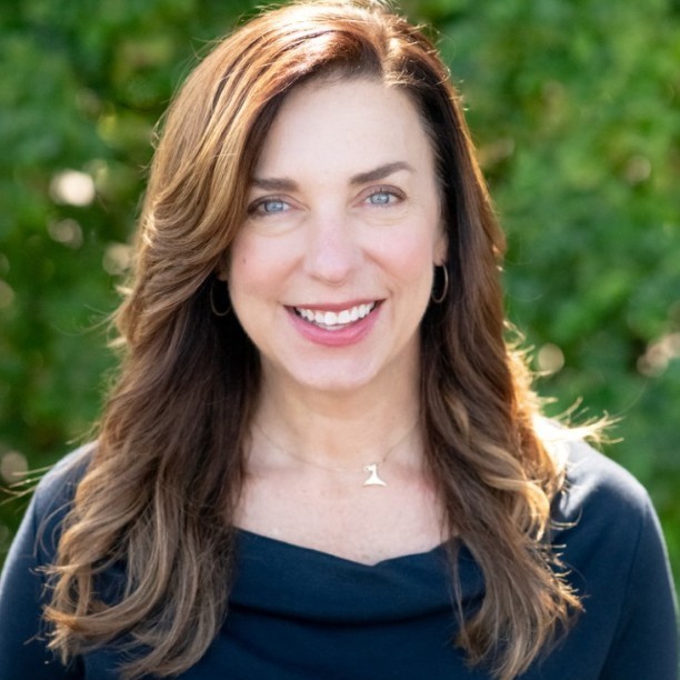 Headshot of Amanda Hooper, a light-skinned woman with brown hair and a dark blue top