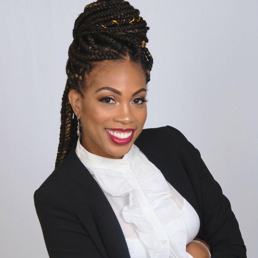 Headshot of Ayana Jordan, a Black woman with long braided black hair and white blouse