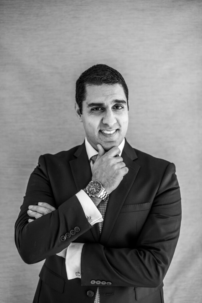 Black and white photo of Sam Sepah, a Persian man with black hair, white shirt, and blazer.