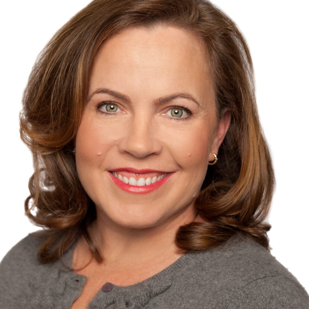 Headshot of Kat Gordon, a White woman with brown hair and a grey sweater.
