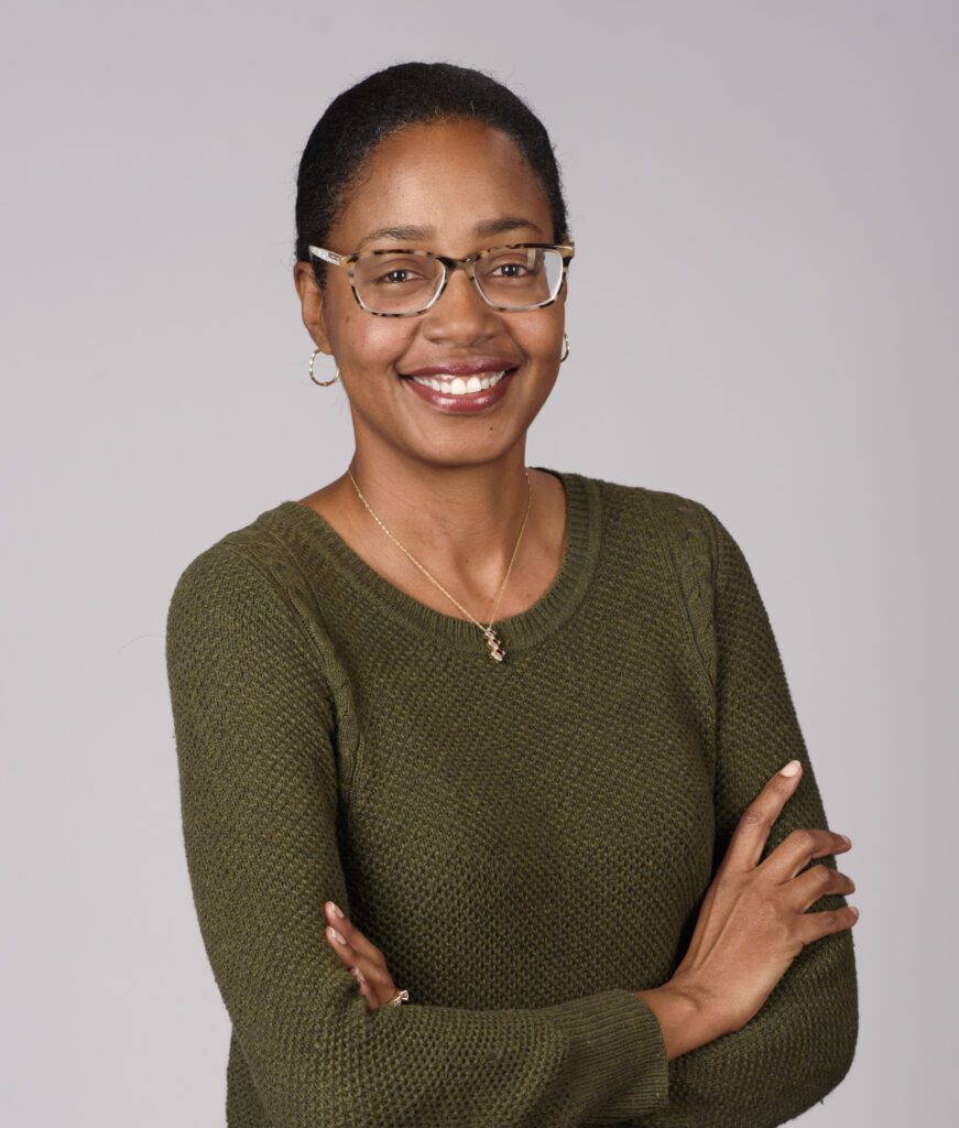 Headshot of Sonja Gittens Ottley, a Black woman with black hair, glasses, and a green shirt.