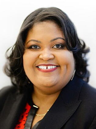 Headshot of LaTricia Frederick, an African American woman with short black curled hair wearing a black blazer and a red and black top